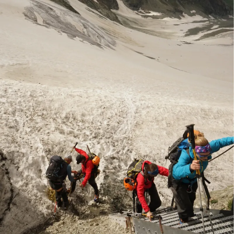 group of mountaineers climbing up ladder