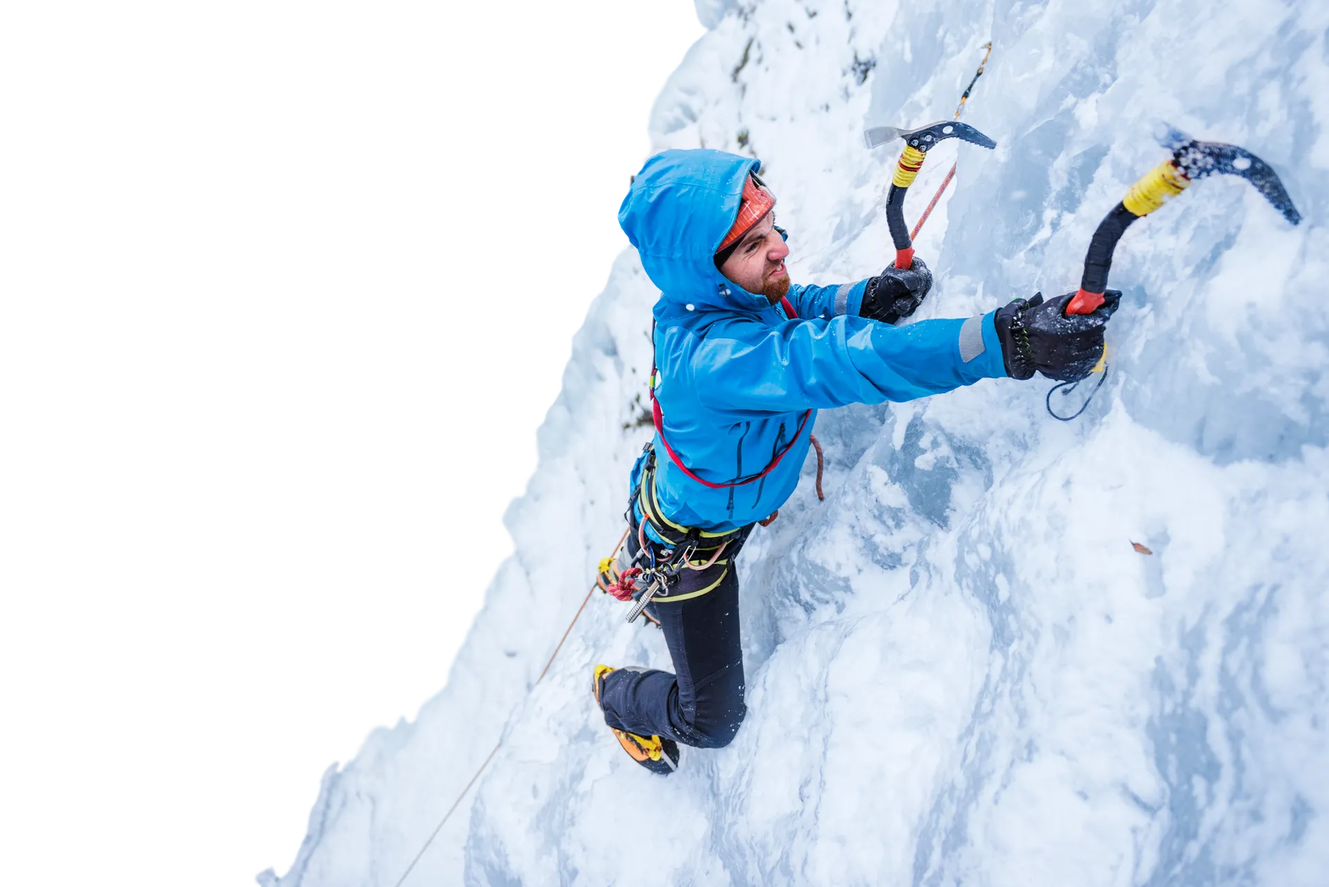 man in blue jacket ice climbing on steep rock face