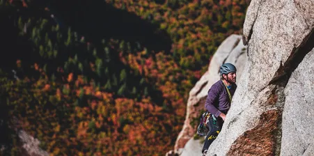 man climbing a steep rock face