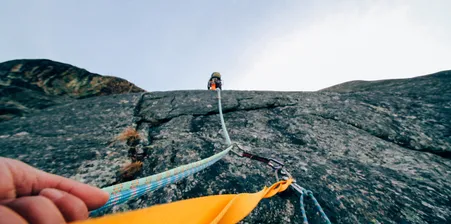 Image of rope with someone trad climbing above
