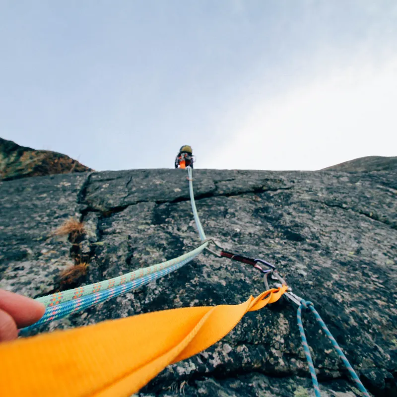 Image of rope with someone trad climbing above