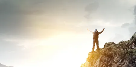 man standing on top of rocks celebrating